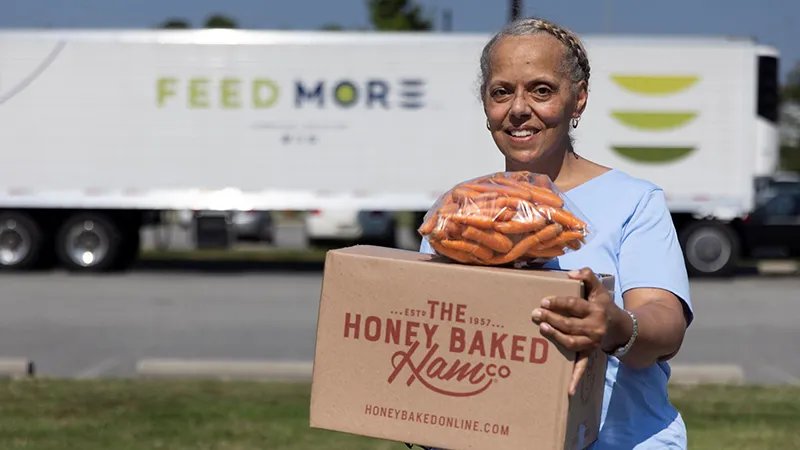 Feed More - Woman holding donated food